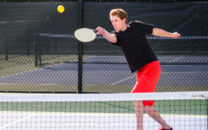 Young Man Serving Pickle ball