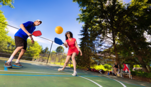 Adult man and woman playing pickleball